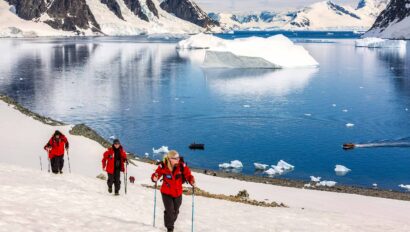 Three people hiking along the Danco Coast in Antarctica.