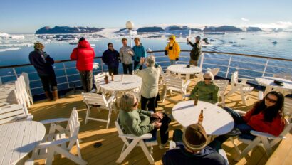 A group of travelers on the deck of a ship in Antarctica.