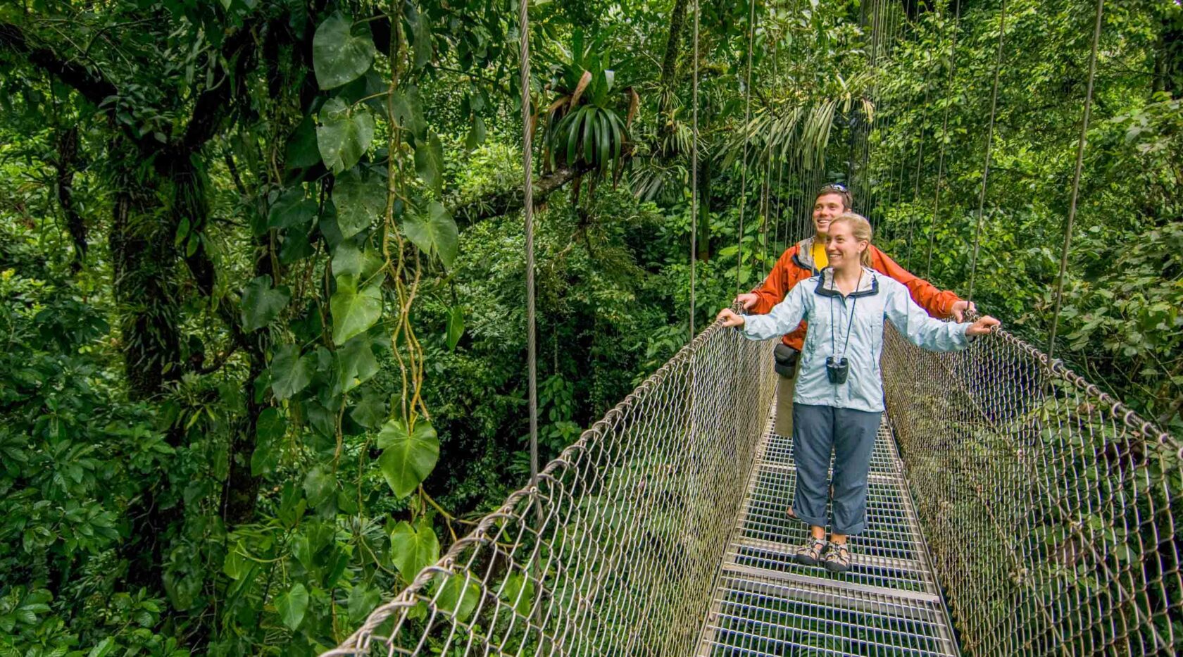 A couple walking on the Arenal hanging bridges in Costa Rica.