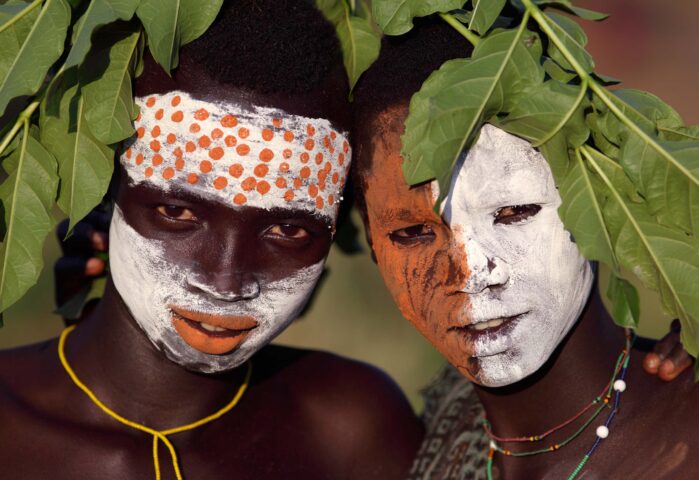 Two Ethiopian people in traditional face paint.