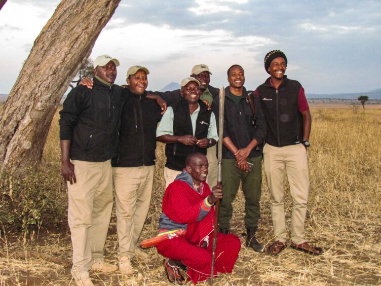 Group of tour guides in Zimbabwe posing by a tree.
