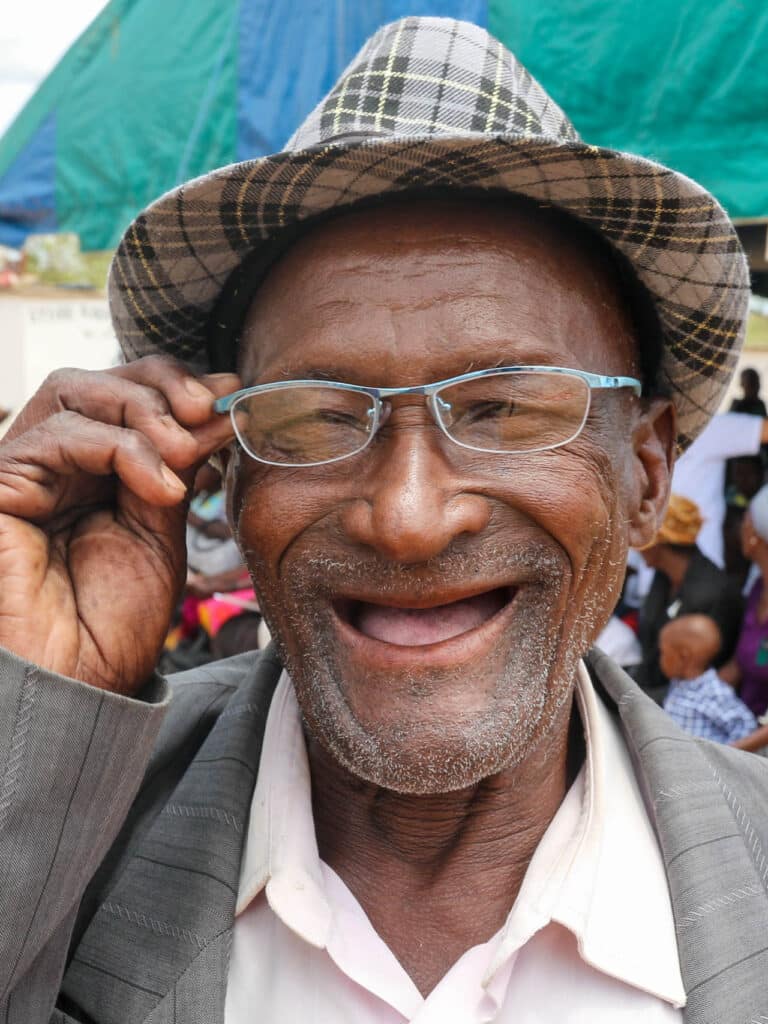 Man in Zimbabwe smiling while wearing new glasses.
