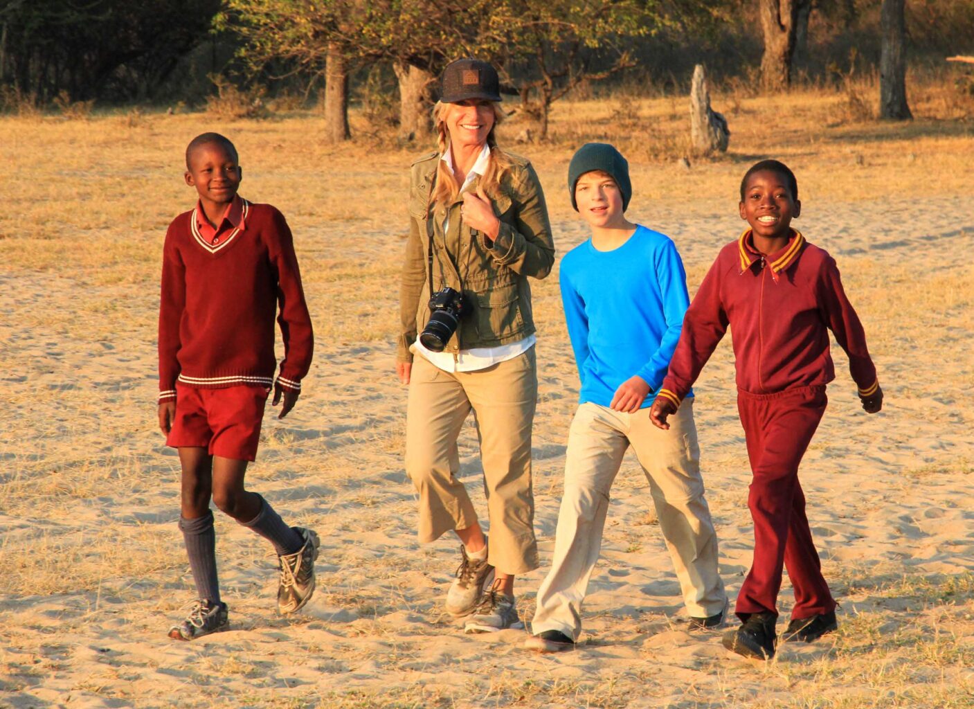 Travelers walking to school with kids in Zimbabwe.