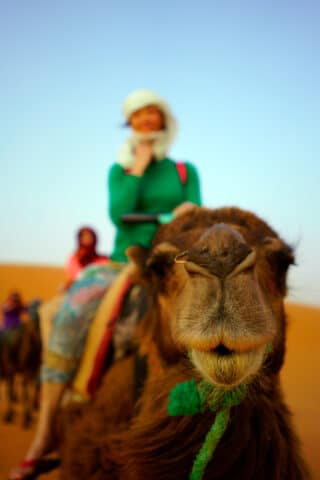 A woman riding a camel.