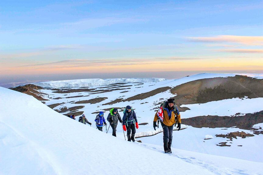 A group of mountaineers, reminiscent of a family adventure with Grandmother and Mother leading the way, climb a snow-covered slope in a high-altitude, arctic landscape with glaciers and a colorful sky in the background.
